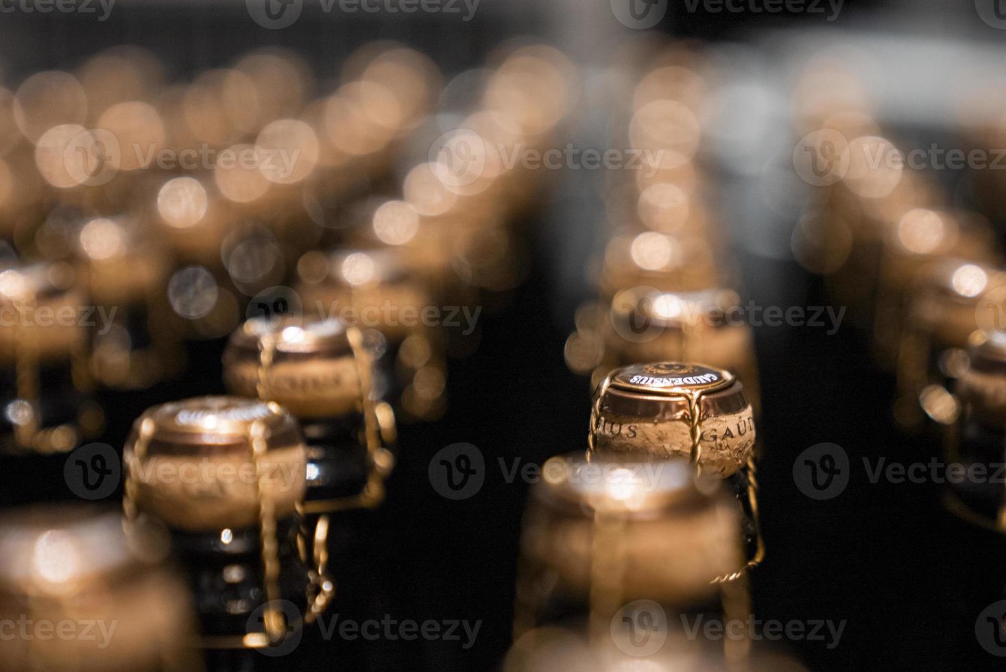 Close-up of sealed glass bottles arranged in storage container in winery photo