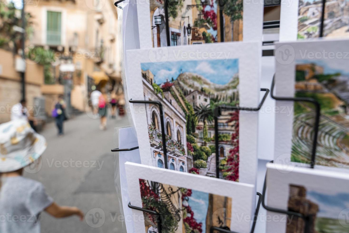 Close-up of postcards on rack for sale at street side in coastal city photo