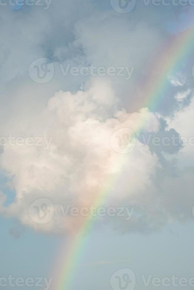 Scenic view of rainbow amidst fluffy clouds in sky on sunny day photo