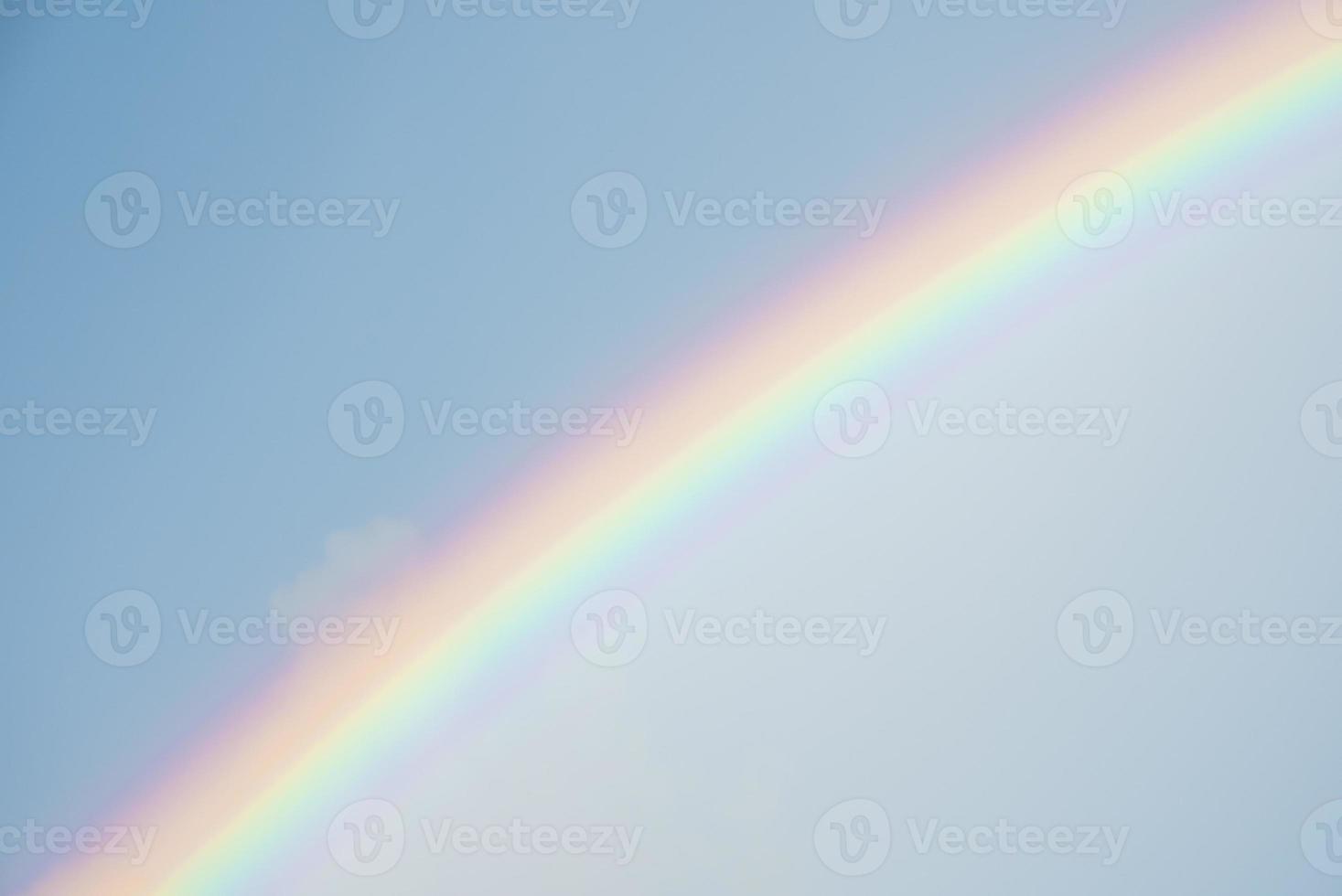 hermosa vista del arco iris en medio de las nubes que cubren el cielo azul en un día soleado foto