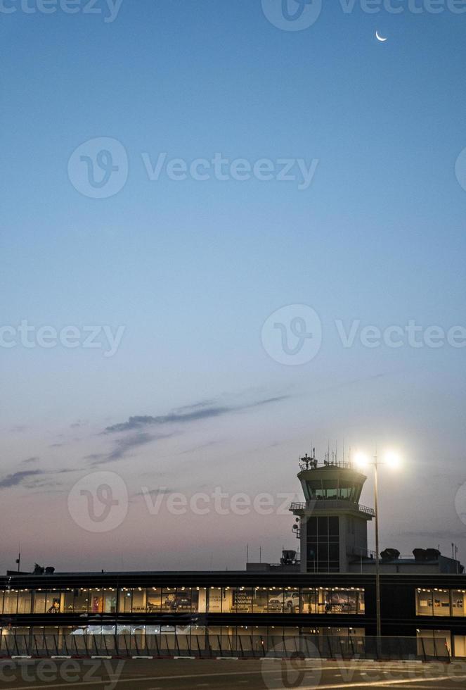 View of illuminated international airport with blue sky in background at dusk photo