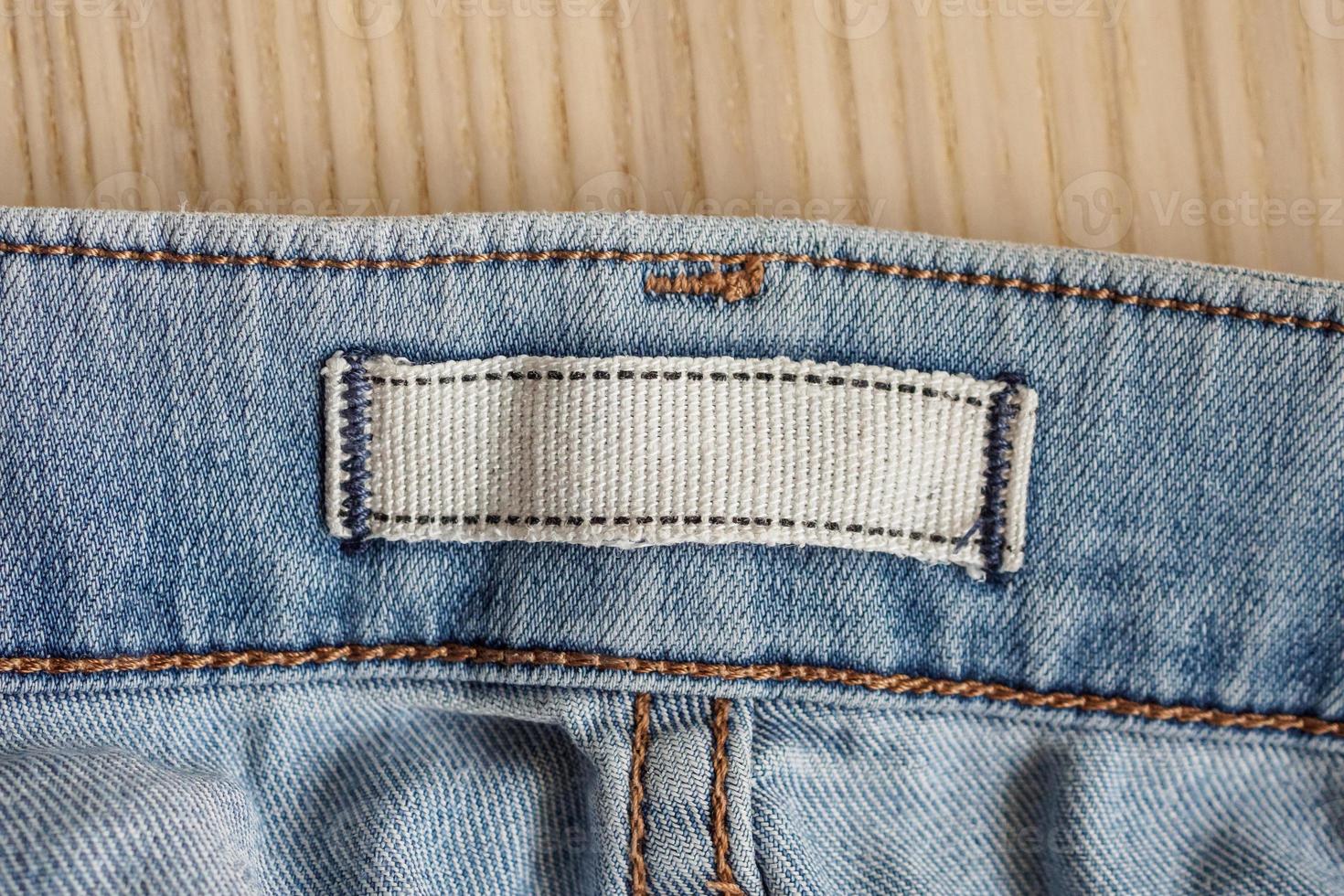 blank clothes label on blue jeans denim background photo