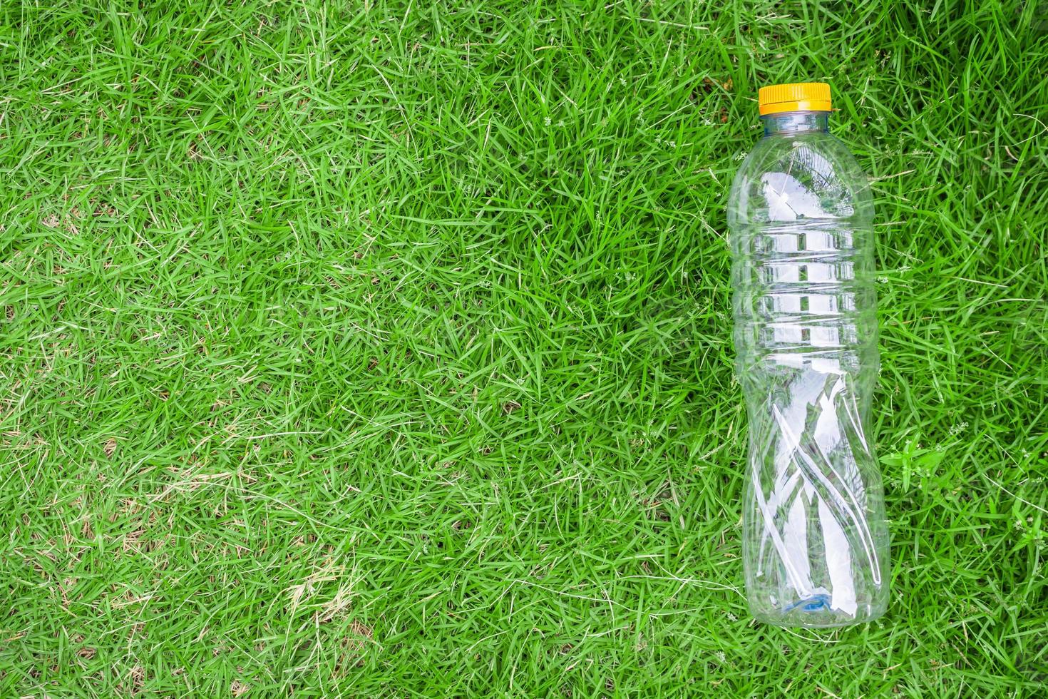 plastic bottle on green grass background recycle and pollution concept photo