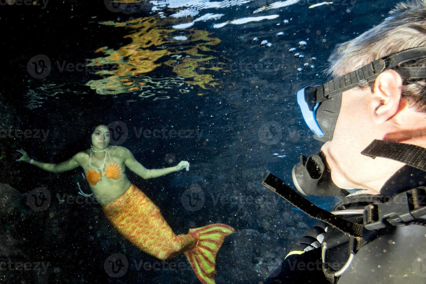 Scuba diver and Mermaid swimming underwater in the deep blue sea photo