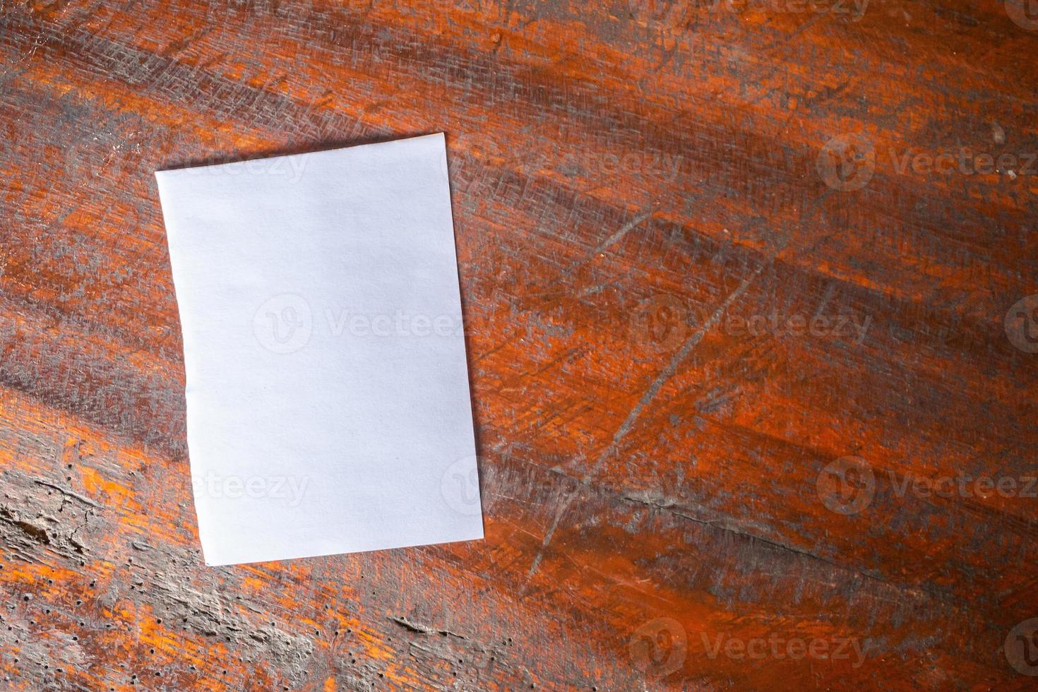 Blank white paper on old rustic wood table background photo