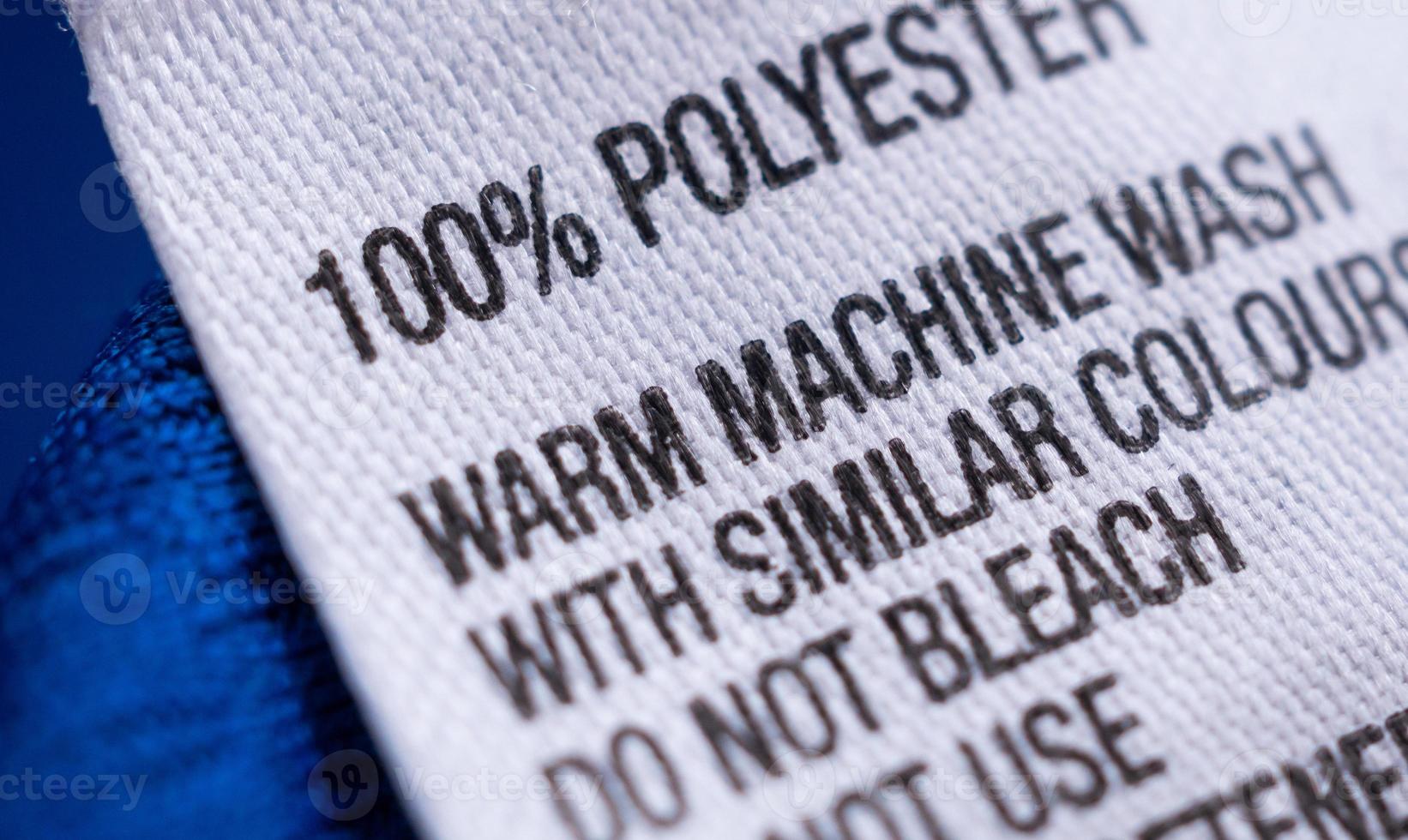 Polyester clothing label with laundry care instructions tag on blue shirt jersey photo