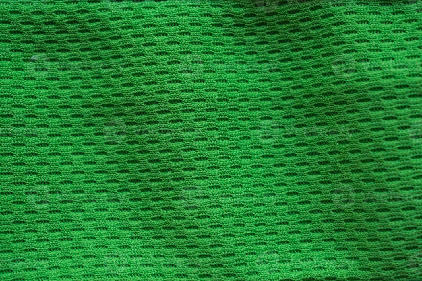 Green fabric sport clothing football jersey with air mesh texture background photo