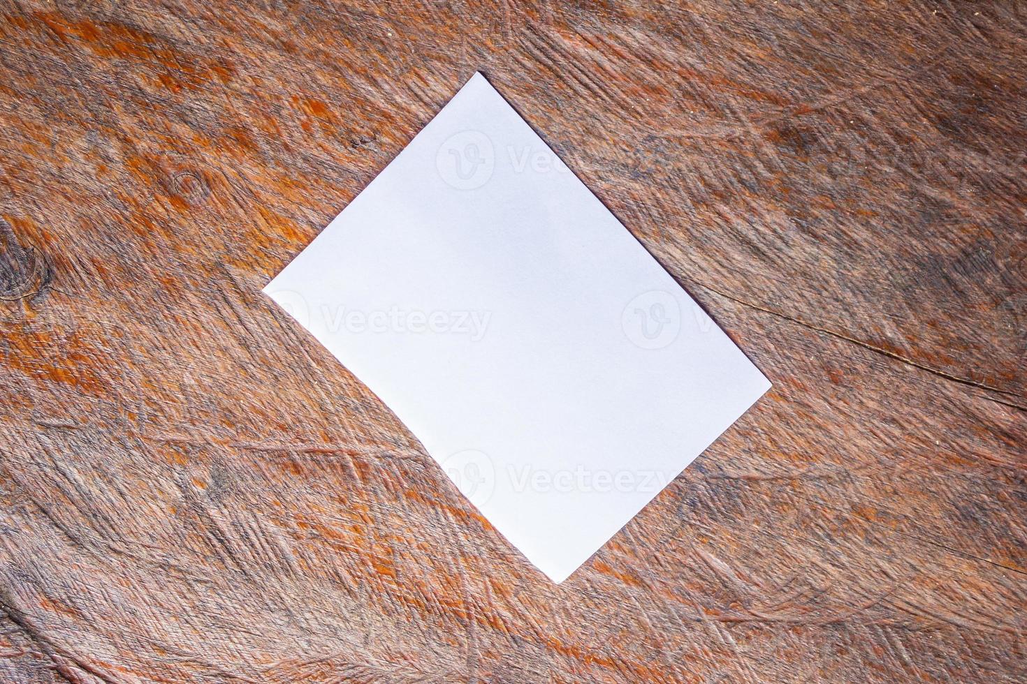 Blank white paper on old rustic wood table background photo