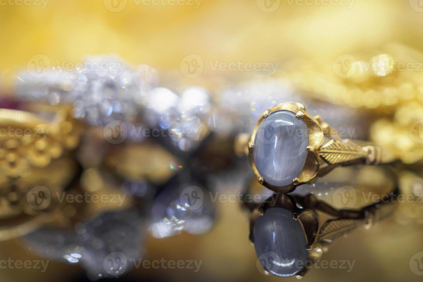 Anillos de zafiro azul de joyería de oro vintage con reflexión sobre fondo negro foto