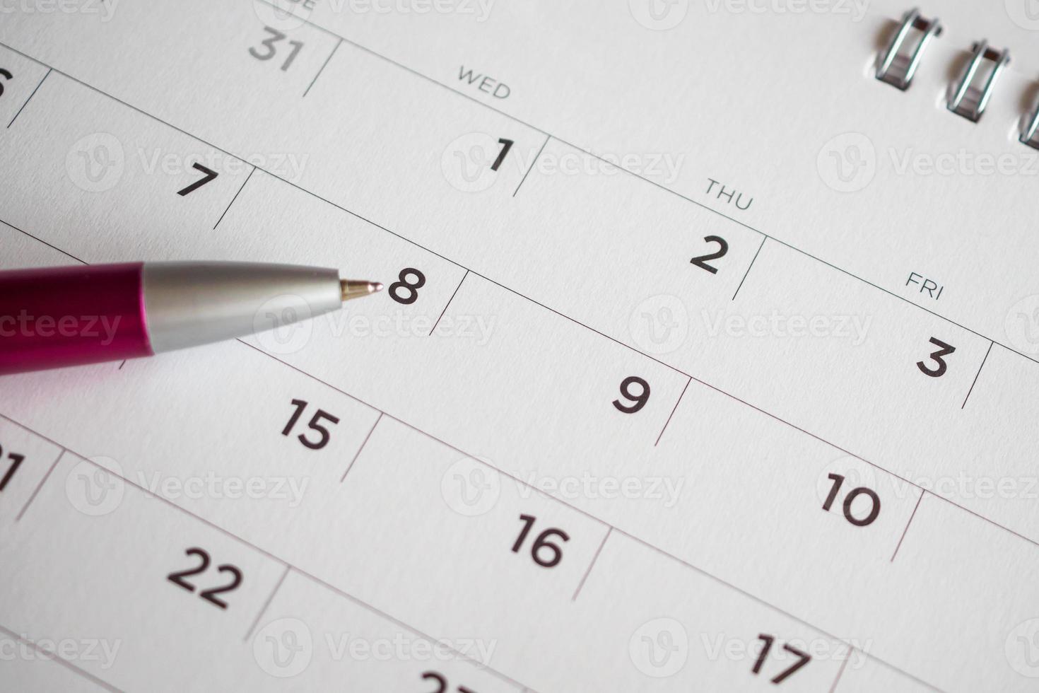 Calendar page with pen point at 8th date photo