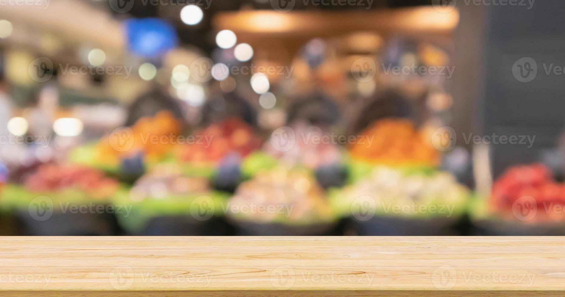 Empty wood table top with abstract blur colorful Fruits in display basket in supermarket grocery store defocused background with bokeh light photo