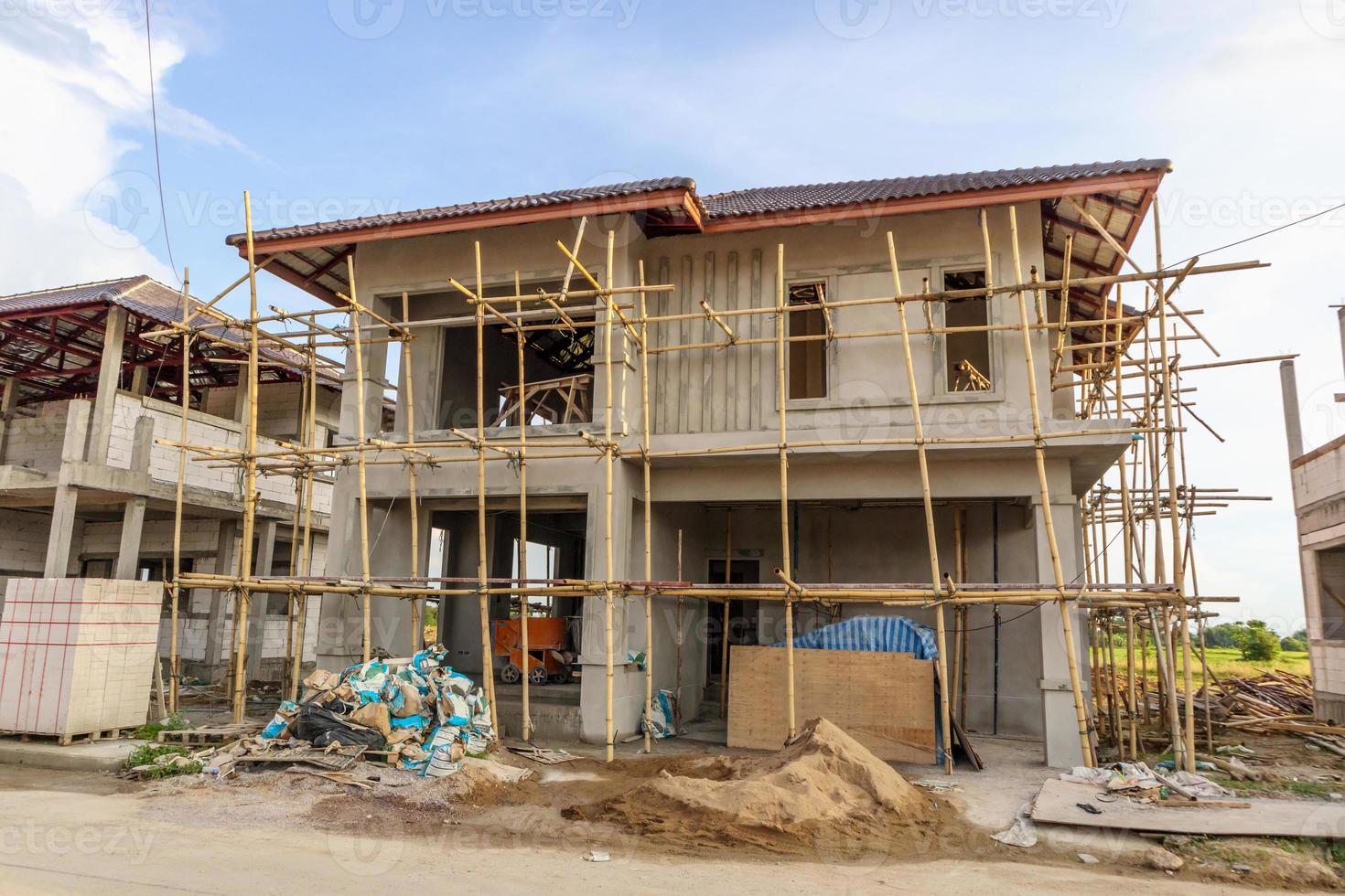 construction residential new house in progress at building site with clouds and blue sky photo