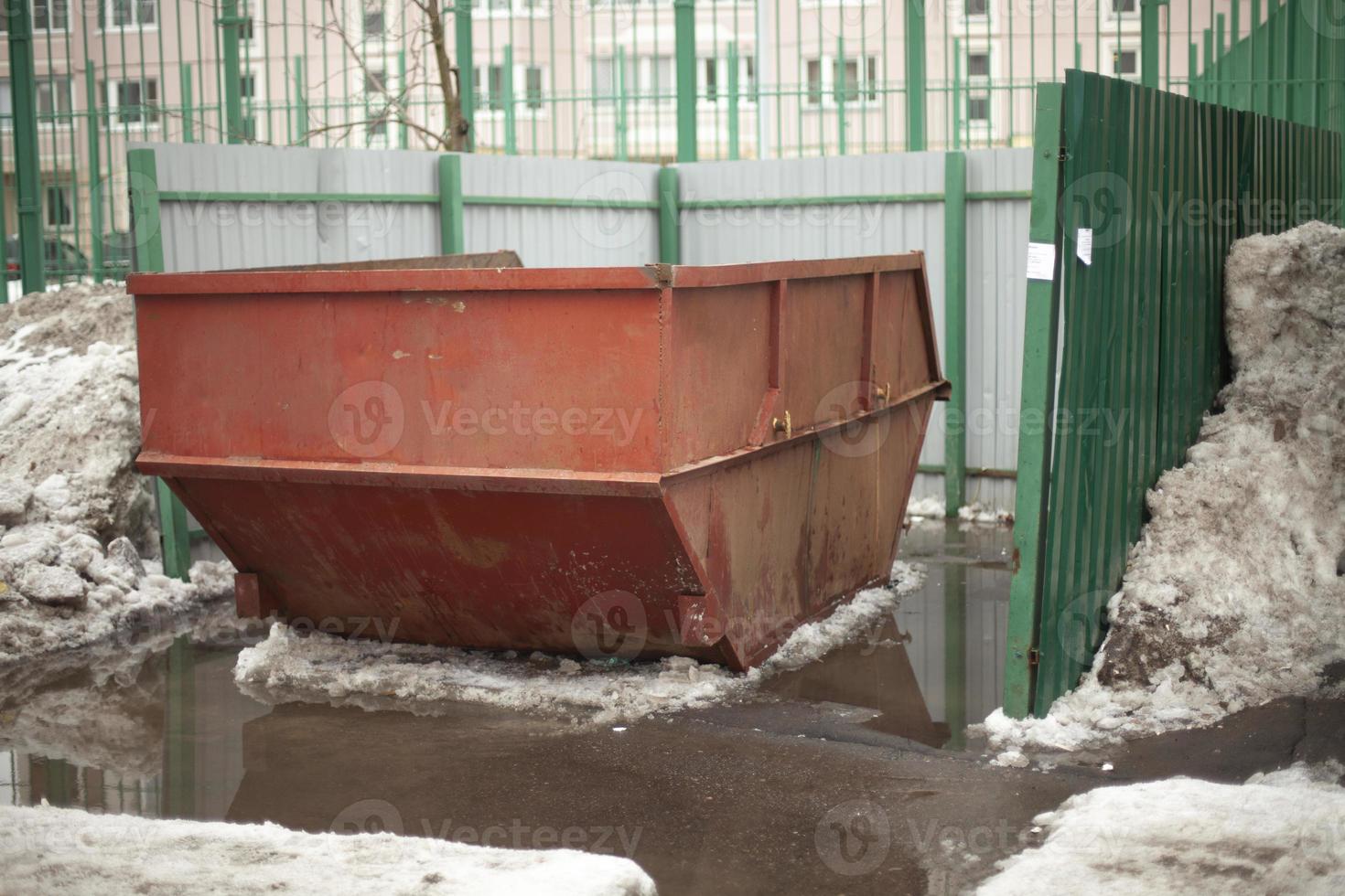Garbage container. Steel waste tank in city. Large garbage can in yard. photo