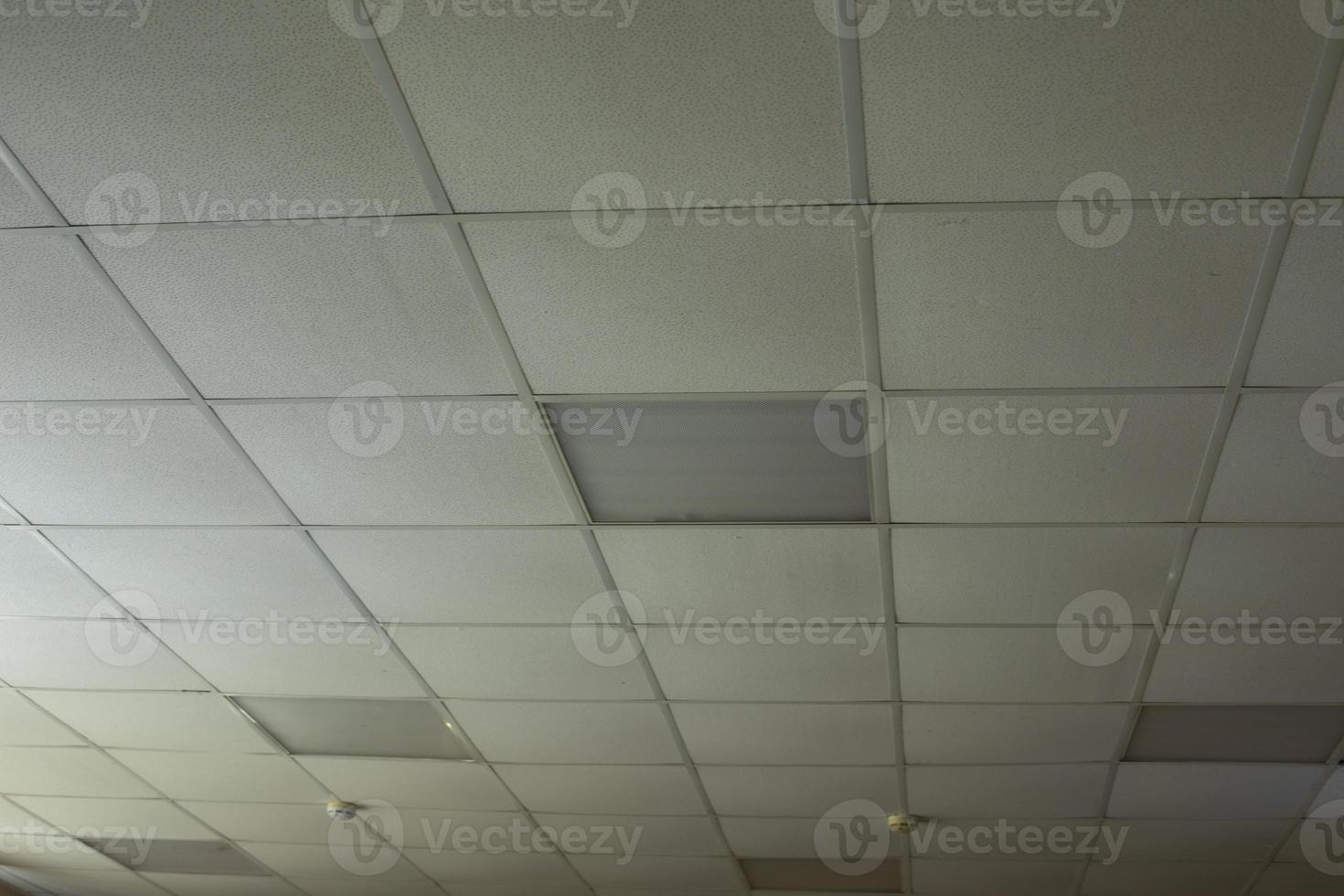 Ceiling is made of tiles in building. Interior of office is in detail. photo