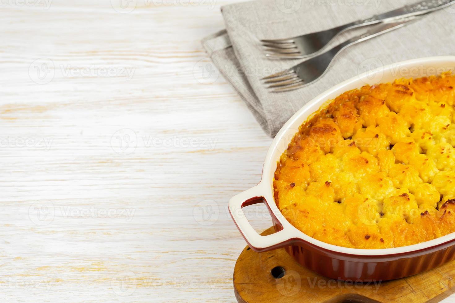 Shepherd's Pie or Cottage Pie, traditional British dish on white wooden background photo