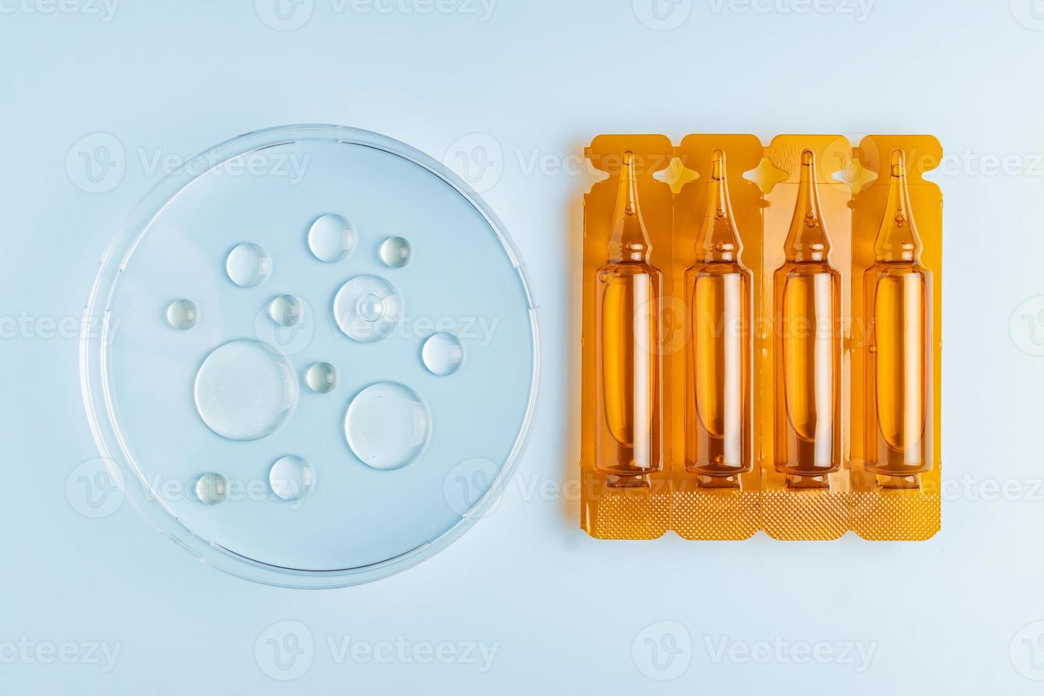 A hair care oil or serum in brown plastic ampiles or capsules on a blue background with oil samples in petri dish, product marketing mockup photo