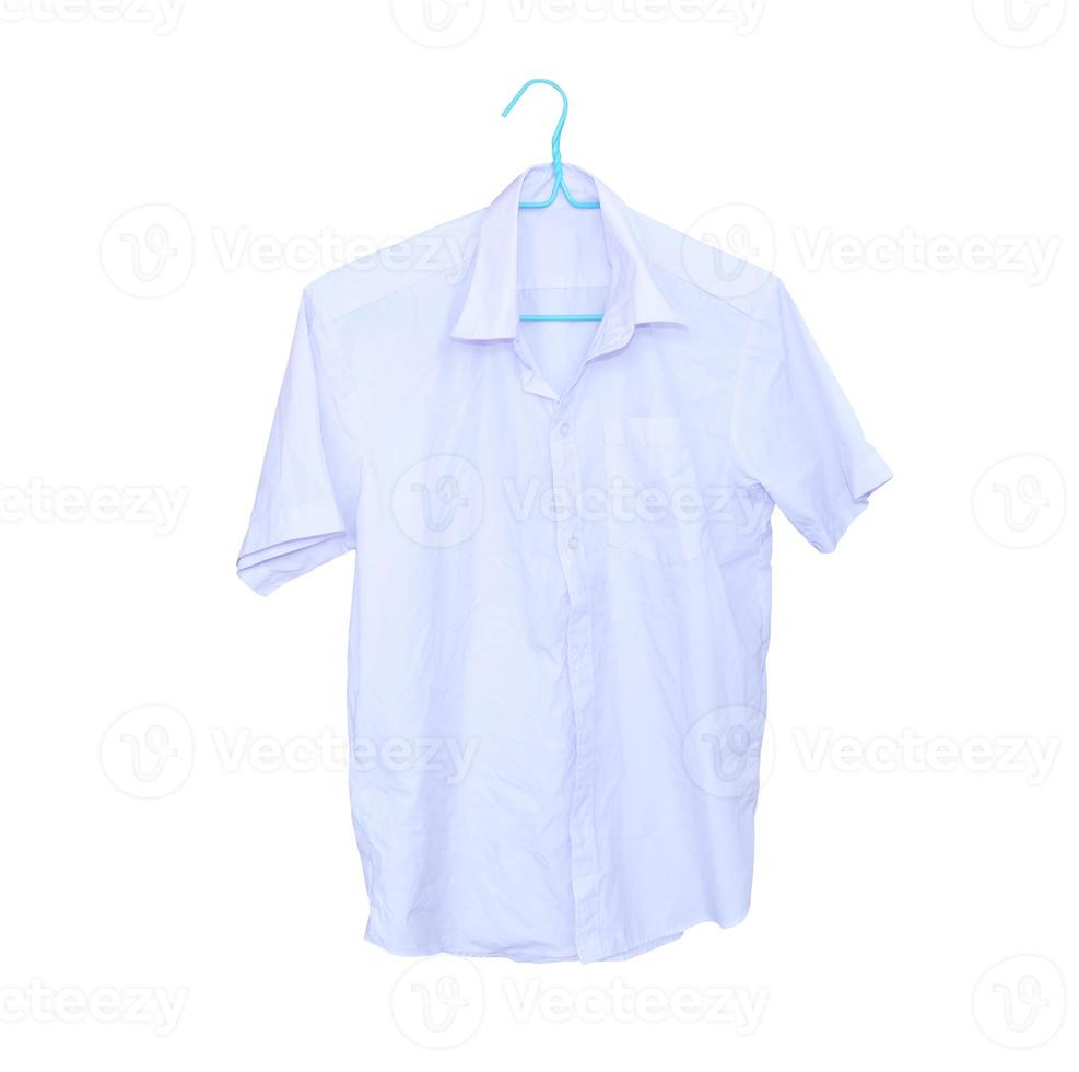 White short sleeved shirt hanging against wooden wall photo