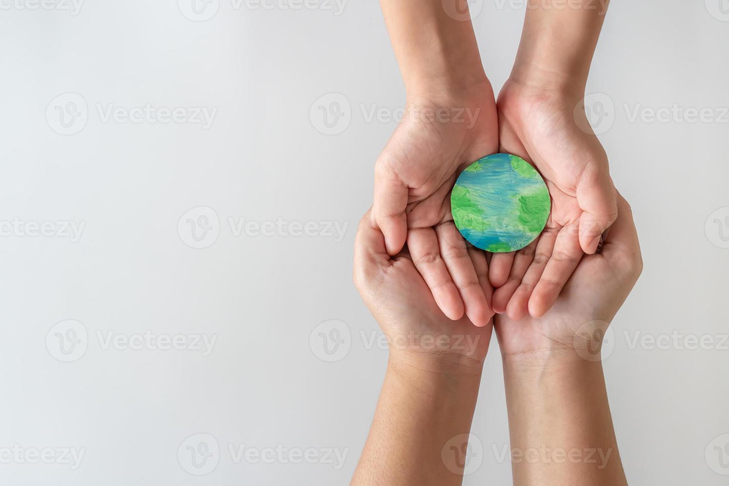 Adult and child hands holding the earth on hand. photo