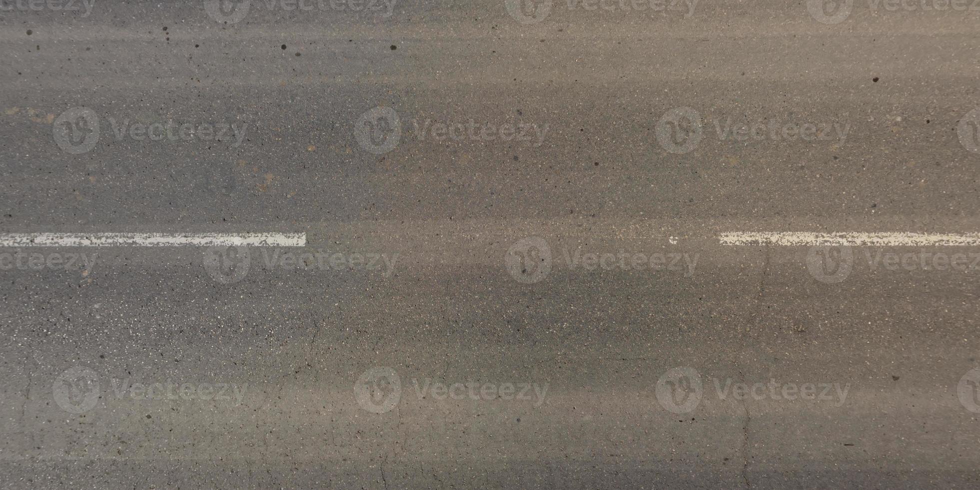 view from above on surface texture of old asphalt road with cracks photo