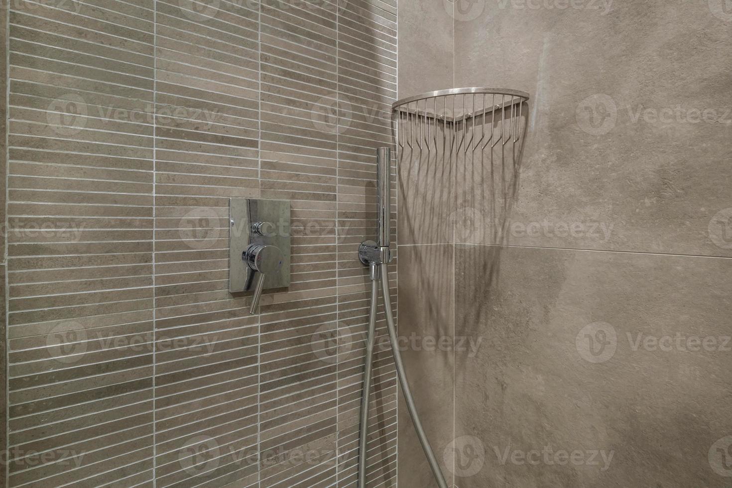 toilet and detail of a corner shower cabin with wall mount shower attachment photo