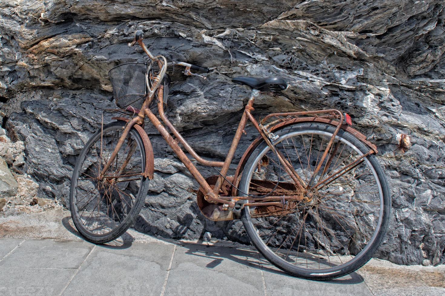 rusted bycicle on rocks background photo