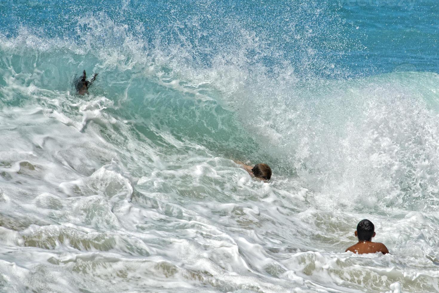children playing in sea waves in hawaii photo