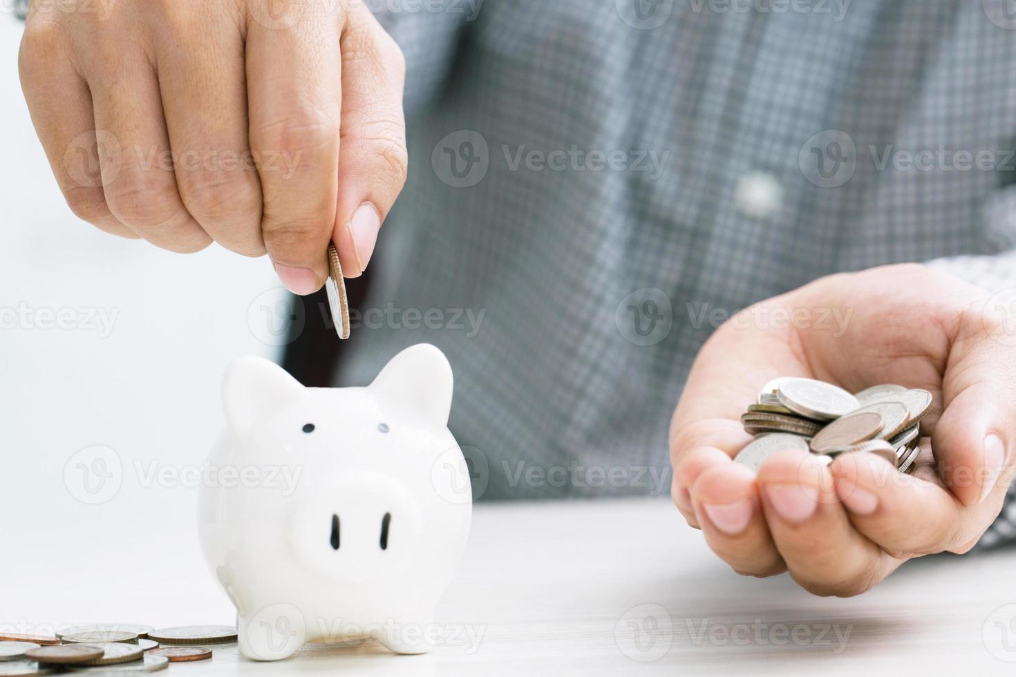 close up hand business man accounting calculate calculator expenses with savings money coins stacked row with hand putting coins Coins drop into piggy bank. concept Write Finance accounting. photo