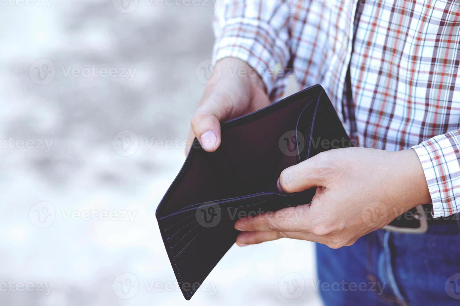 An Empty wallet in the hands of a young man photo