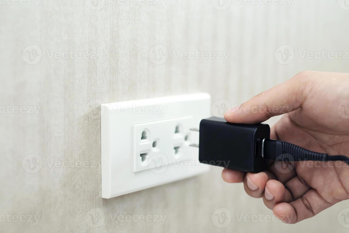 Power plug with socket. Hand holds the plug. Electricity. photo