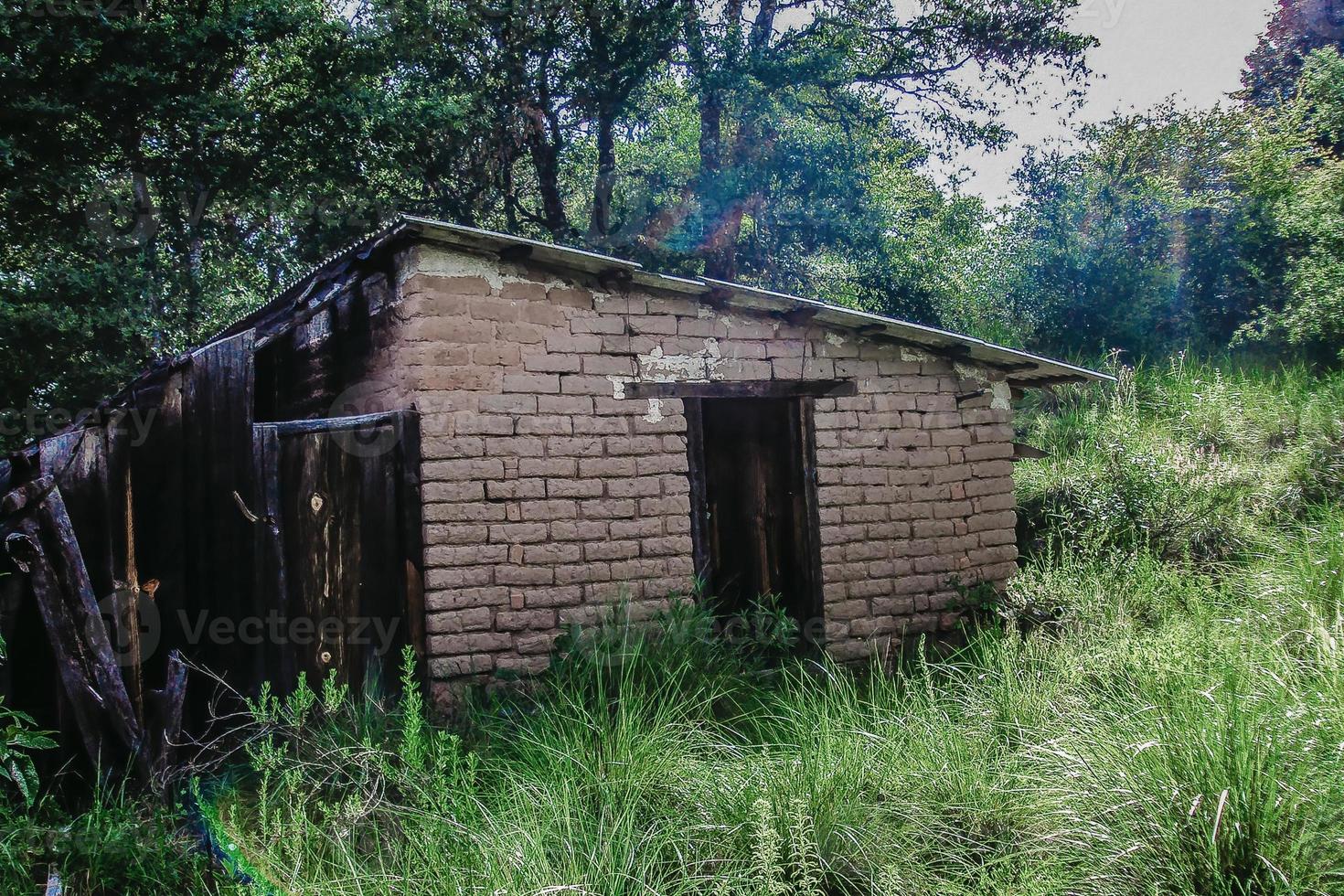 Rural house made of earth in green landscape photo