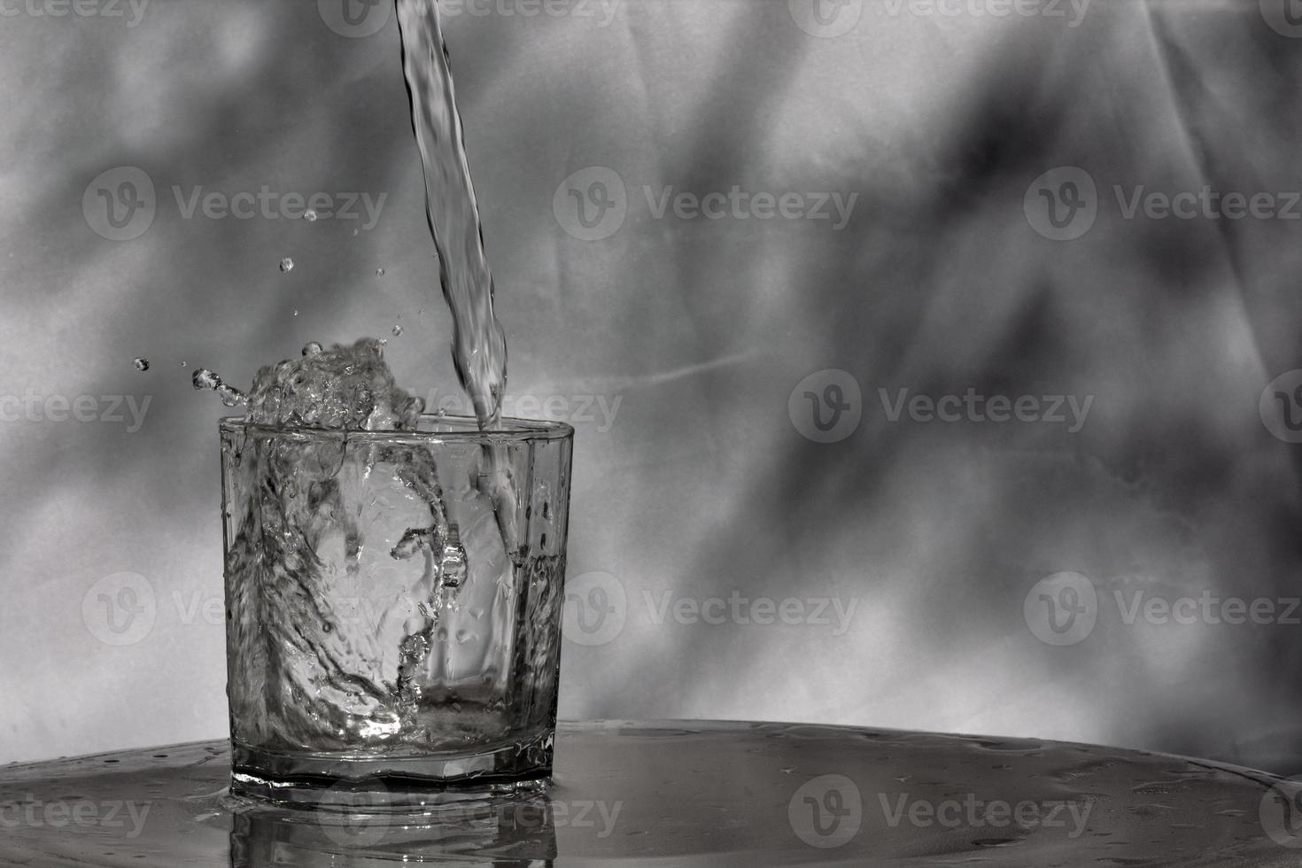 el agua fluye hacia un vaso colocado en una barra de madera foto