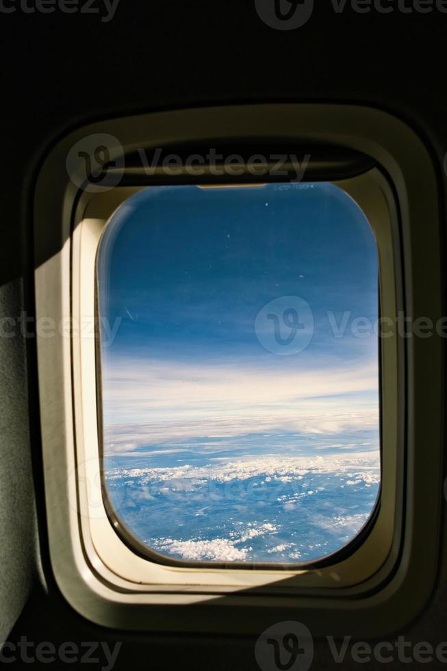 View of blue cloudy sky from airplane window photo