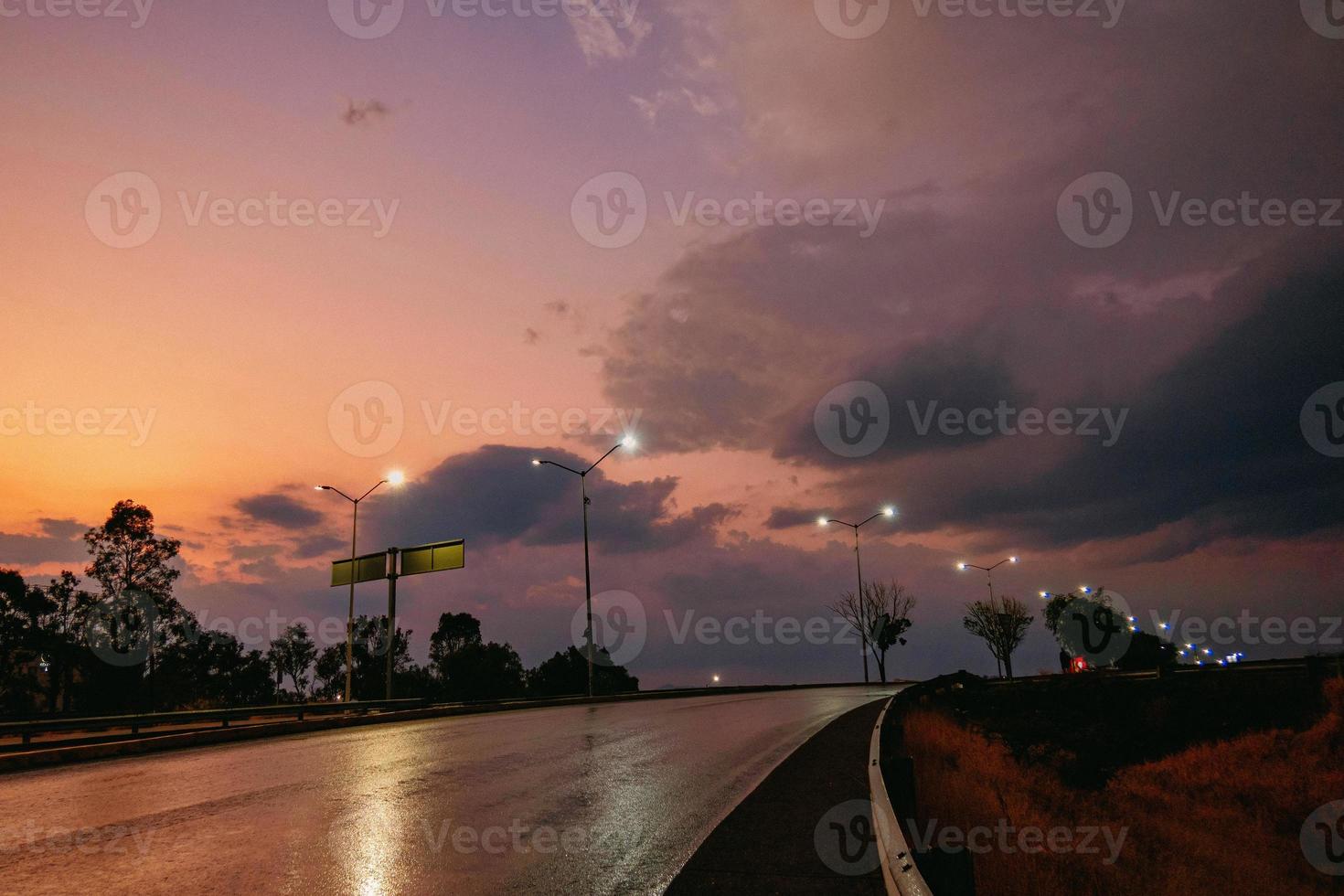 Road illuminated by lamps in beautiful sunset photo