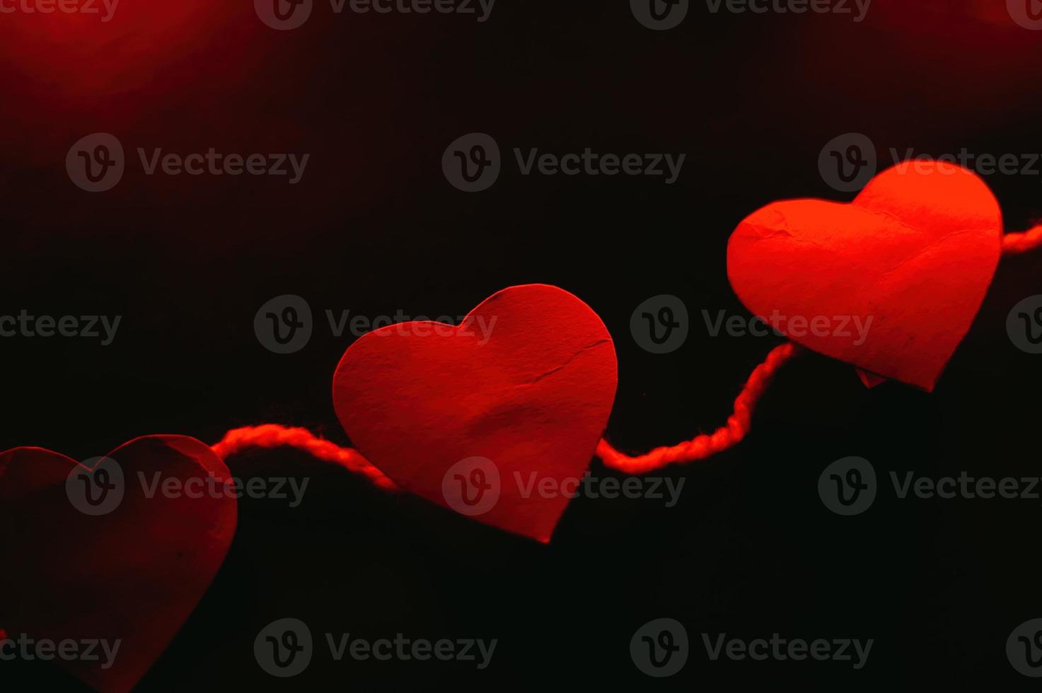 Paper hearts on black background photo