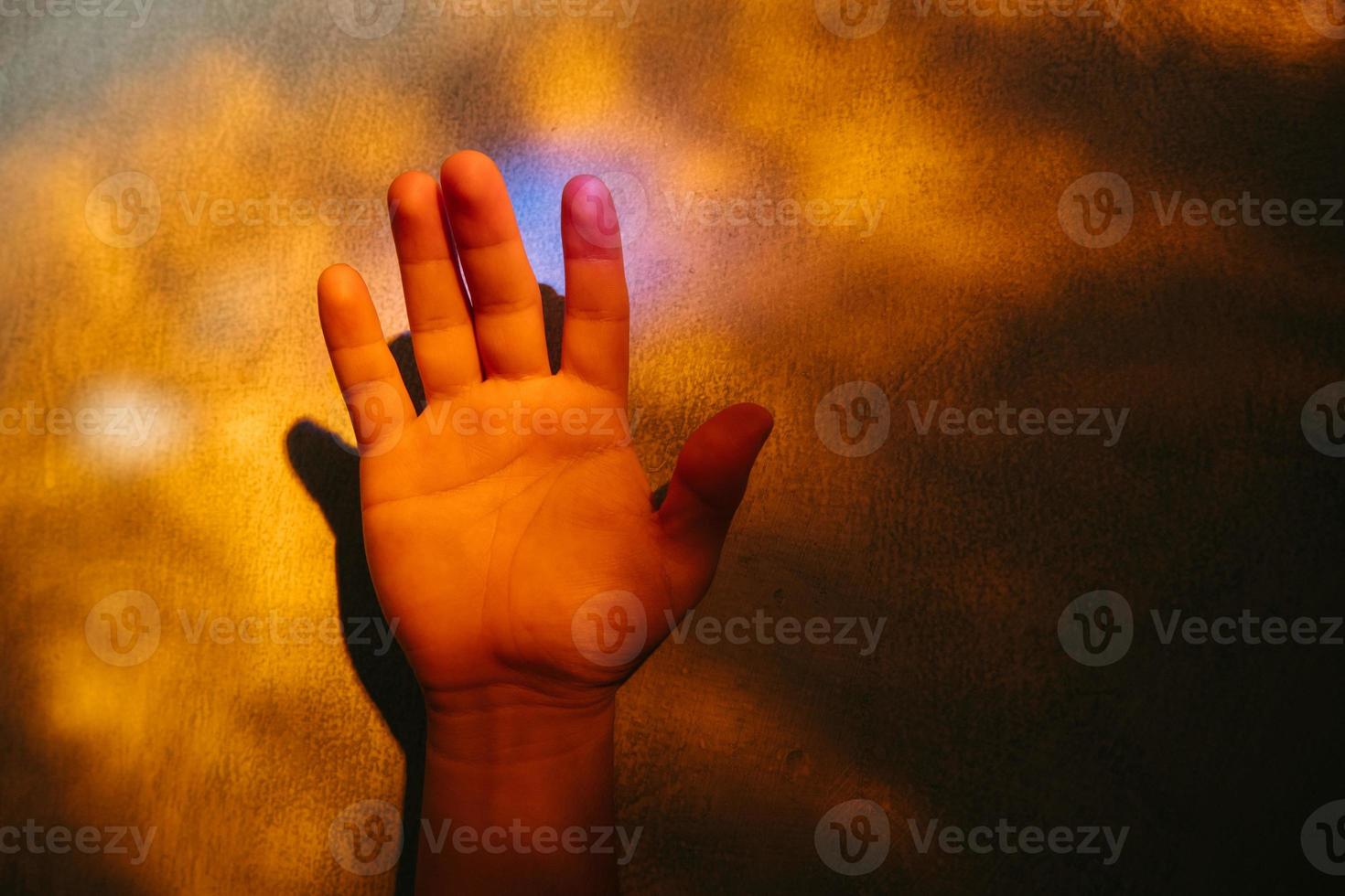 Person holding hand up to the light touching rays of warm photo