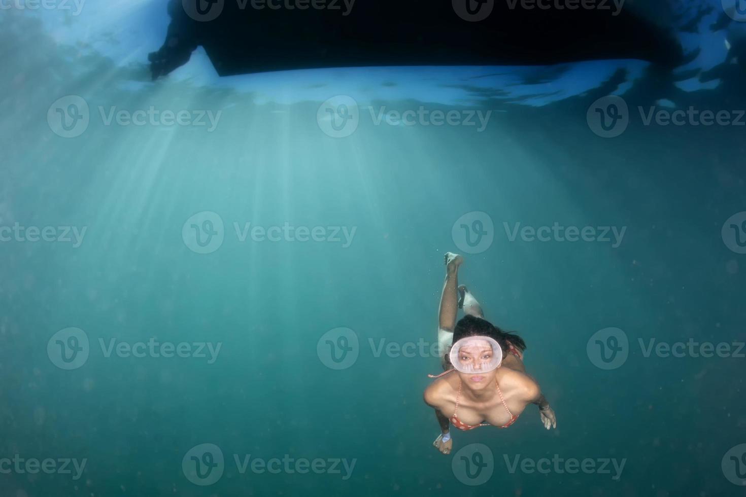 beautiful girl diving in the deep blue sea photo