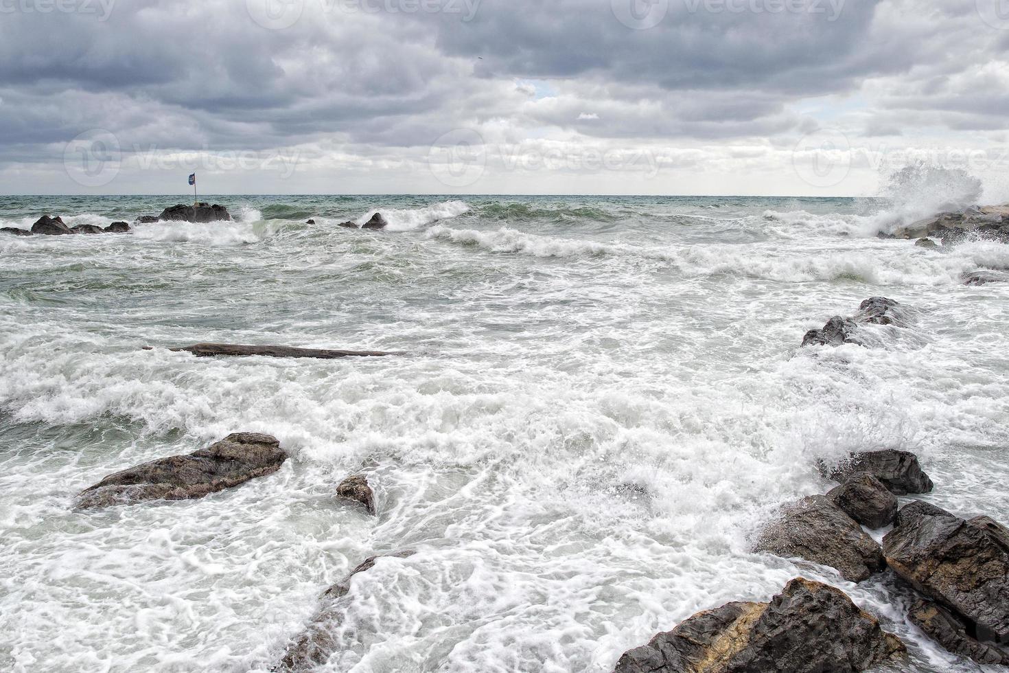 sea in tempest on rocks of italian village photo