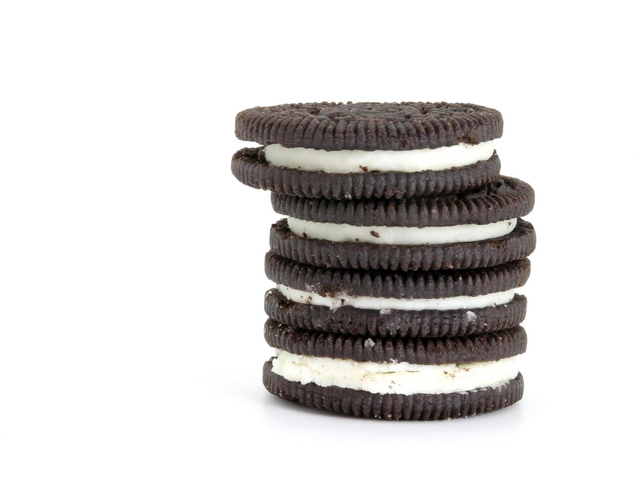 Galletas de chocolate con relleno de crema entre sobre fondo blanco. foto