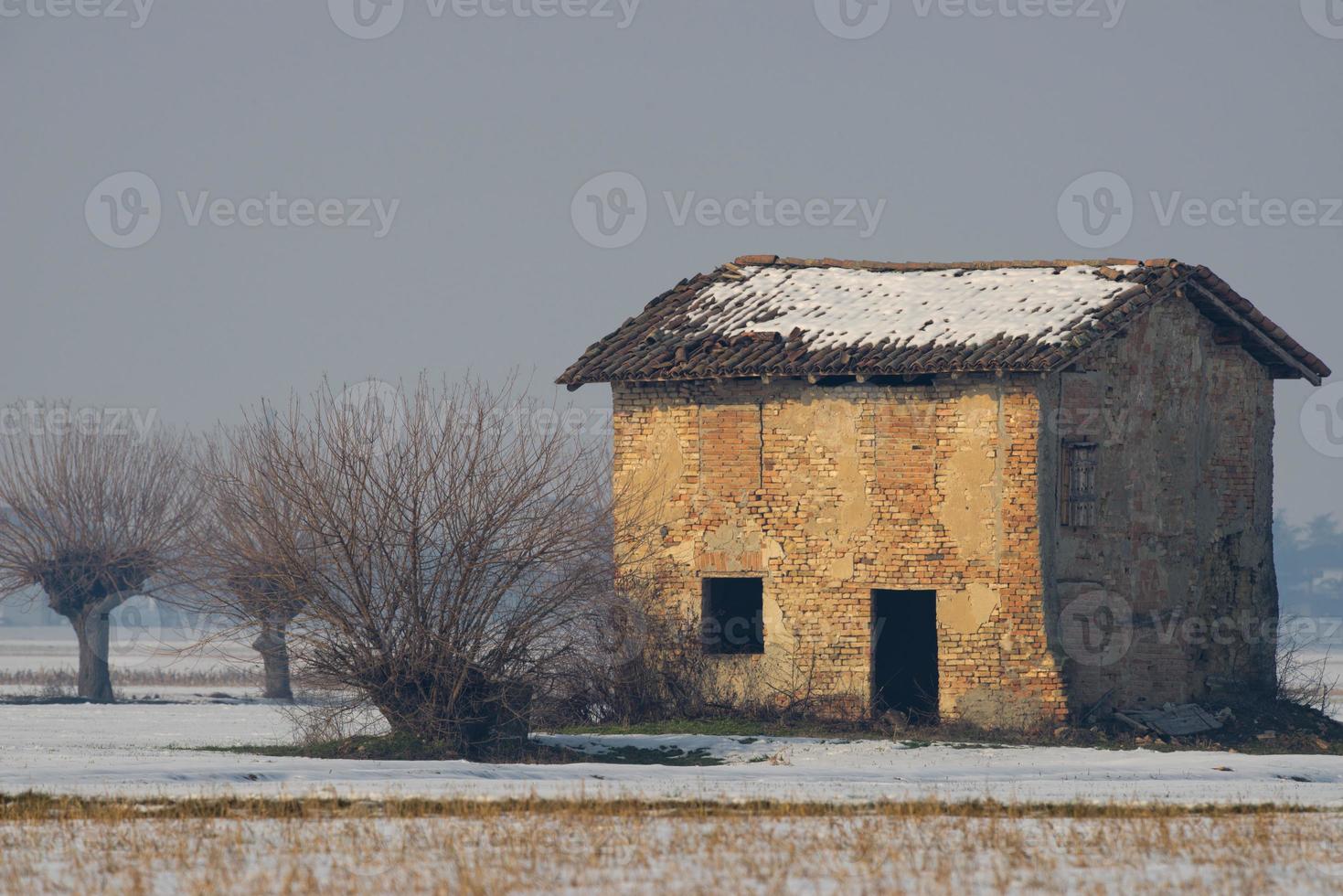 antigua casa de ladrillos cubierta de nieve foto