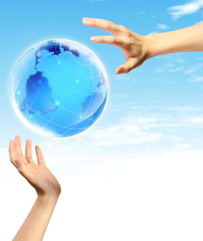 Globe in human hand against blue sky. photo