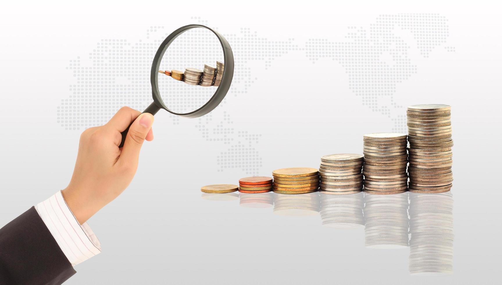 Magnifying glass and lots of gold coins photo