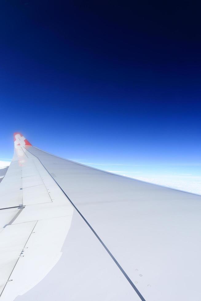 Wing of an airplane flying above the clouds. photo