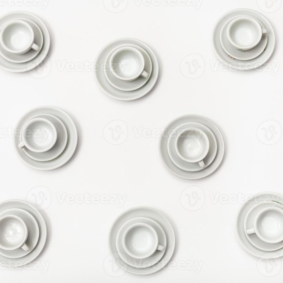 top view several white cups and saucers on white photo