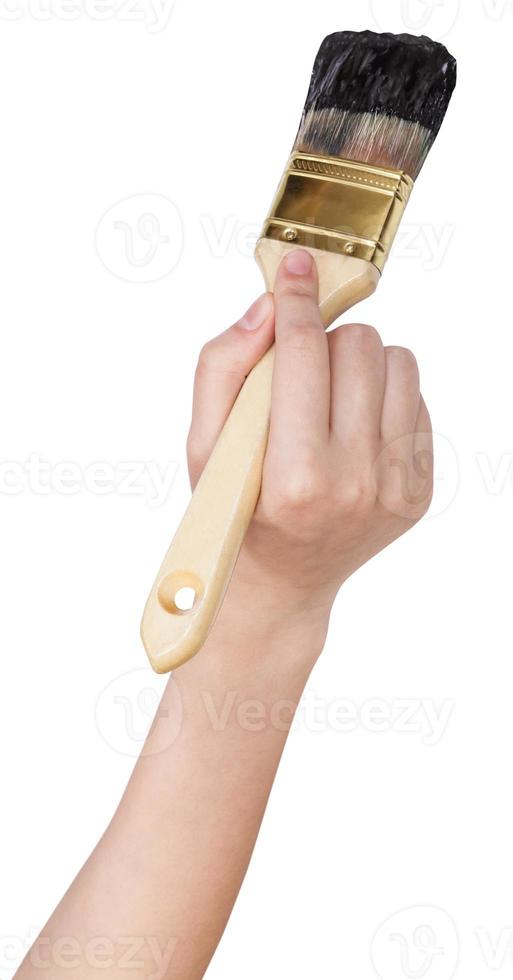 painter hand with flat paint brush paints in black photo