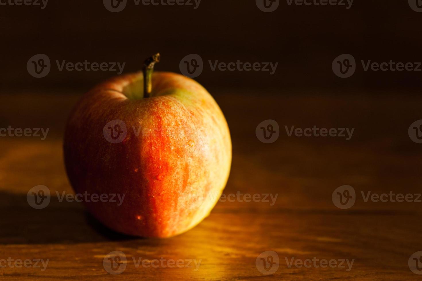 apple on table illuminated by afternoon sunlight photo