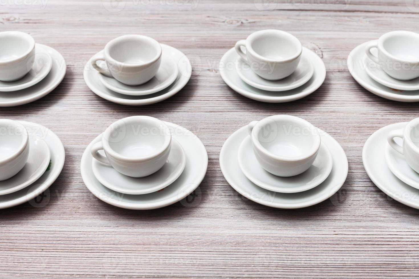 several white cups and saucers on gray brown table photo