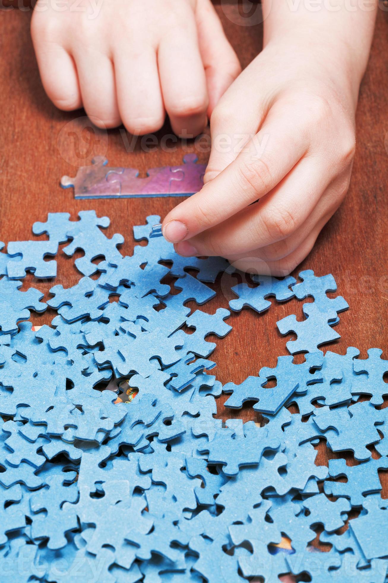 assembling of jigsaw puzzles 12243319 Stock Photo at Vecteezy