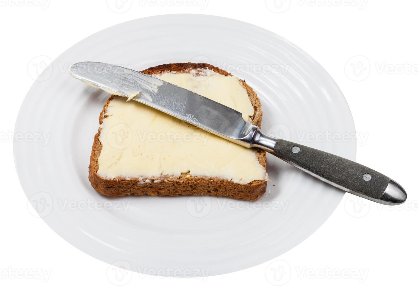 bread and butter with table knife on white plate photo