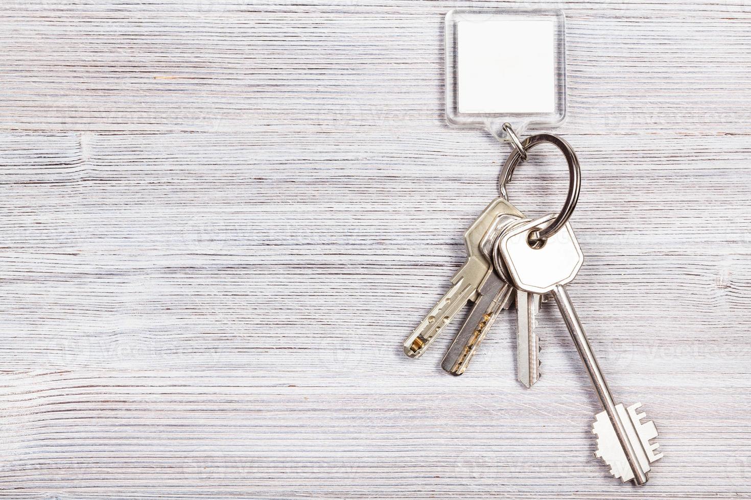 bunch of keys with key chain on wooden board photo