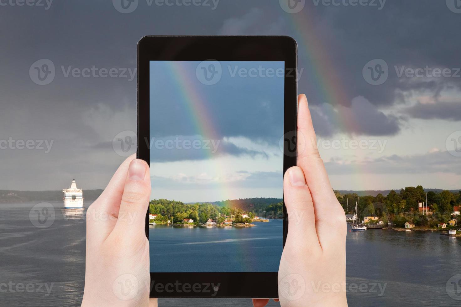 tourist photographs of rainbow over Baltic sea photo